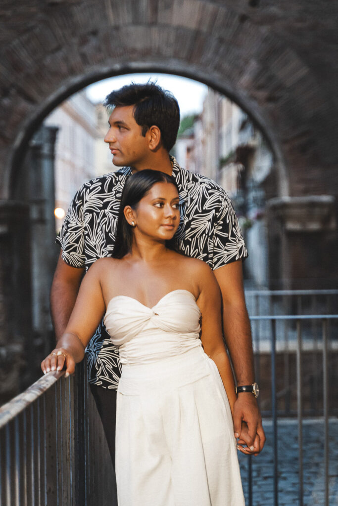 a man and woman standing on a bridge in Rome