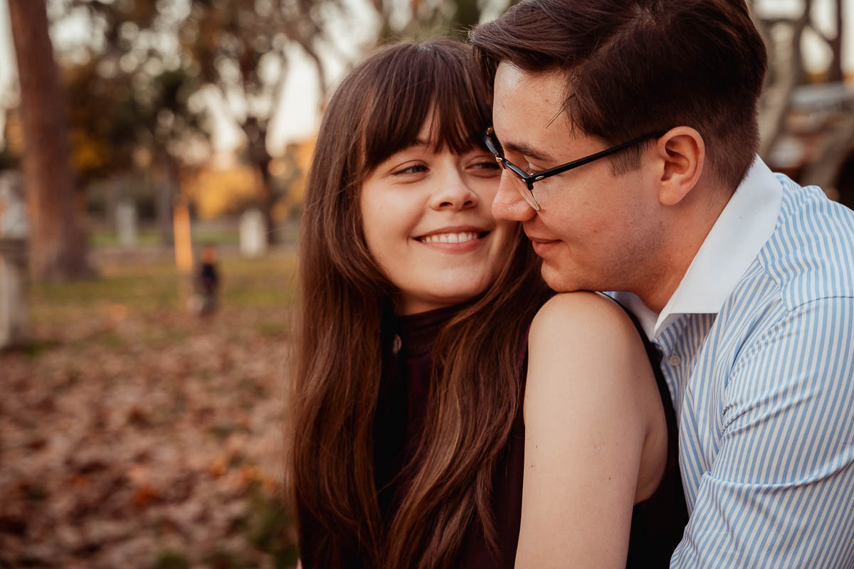 a man and woman hugging and smile at villa borghese - rome