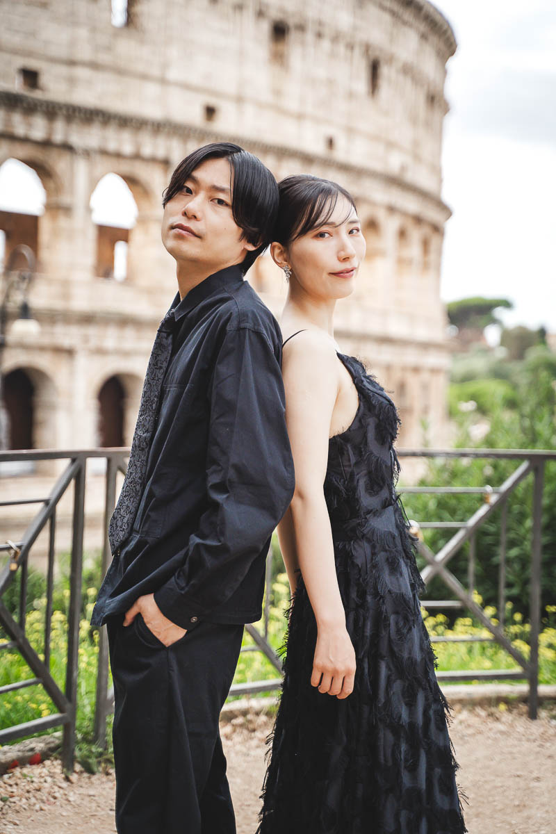a man and woman cool pose in front of colosseum